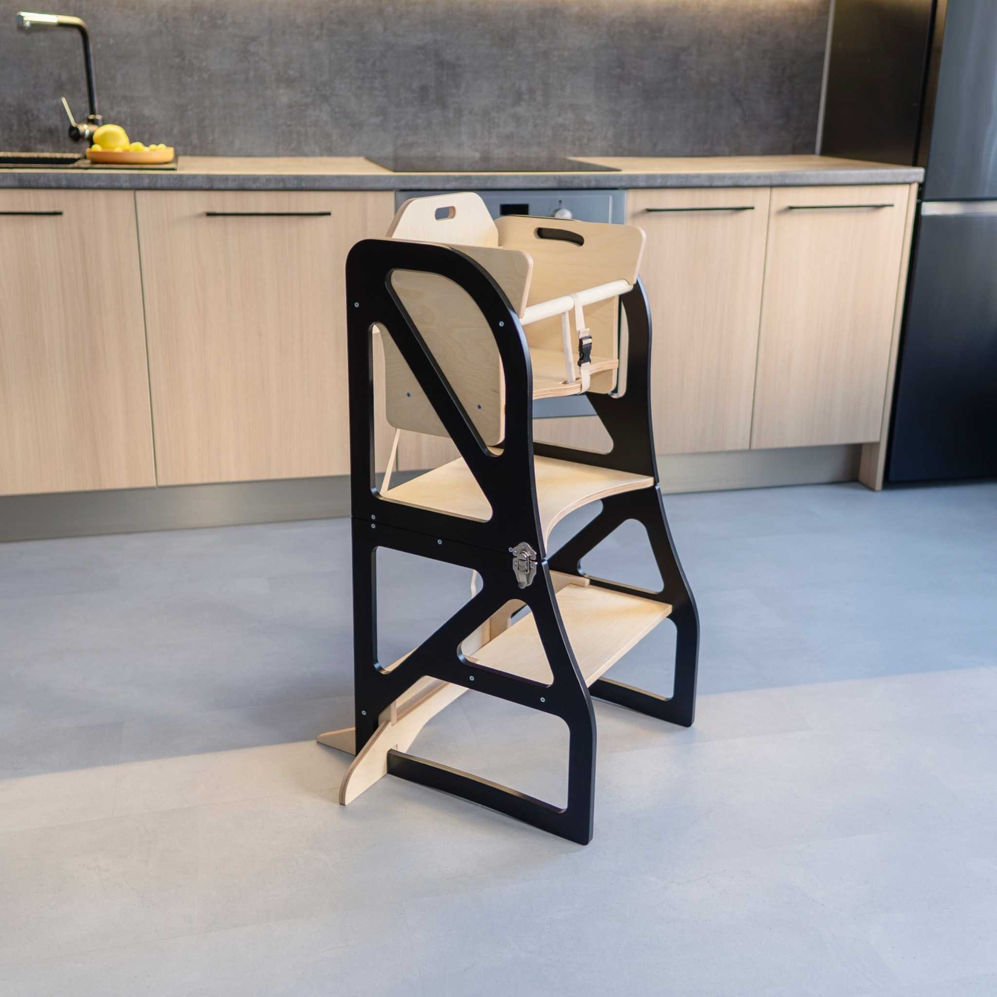 High chair add-on attached to a transformable kitchen tower, creating a secure toddler dining setup