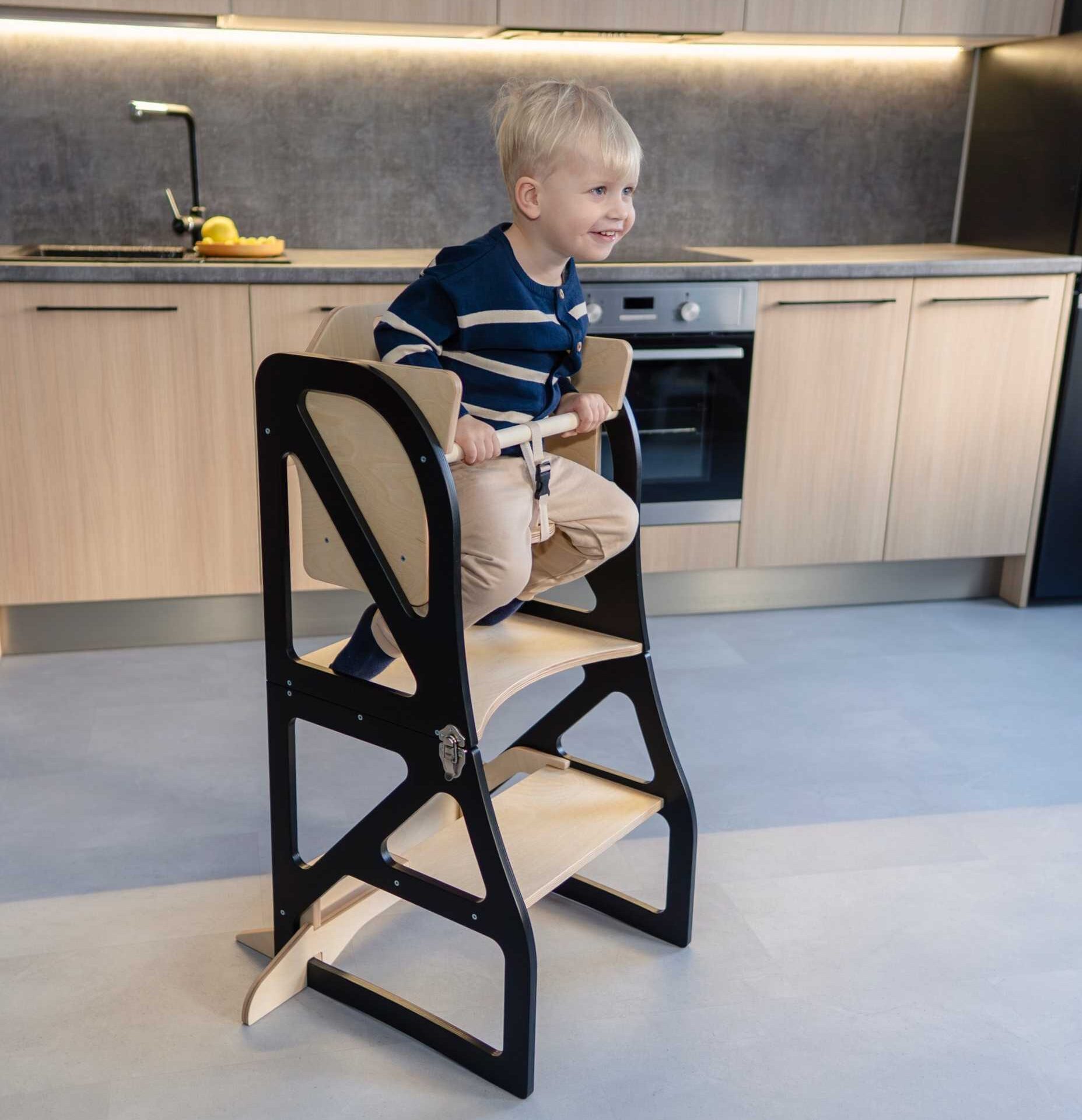 Transformable kitchen tower with high chair add-on used for safe toddler seating in the kitchen