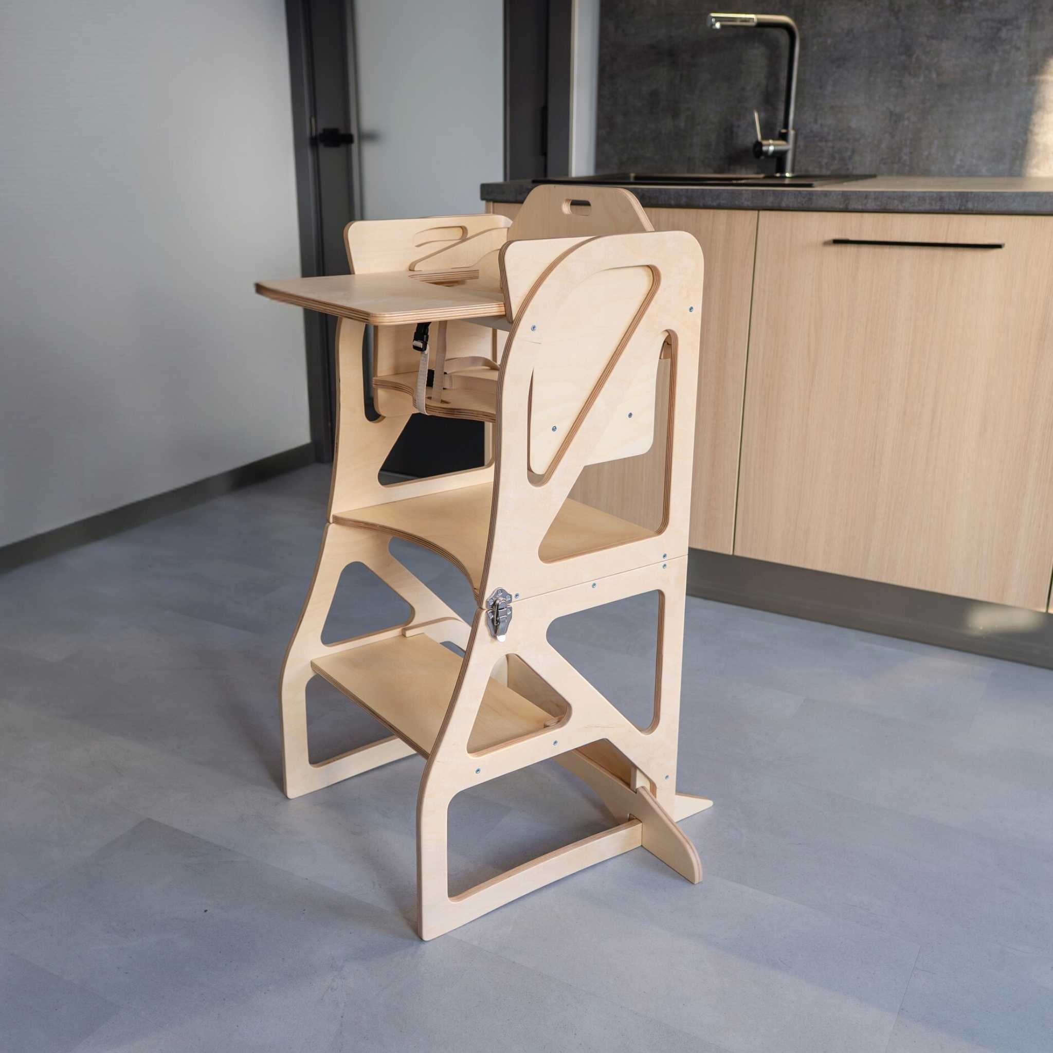 Transformable kitchen tower with high chair and tray add-on, designed for toddler meals and kitchen activities.