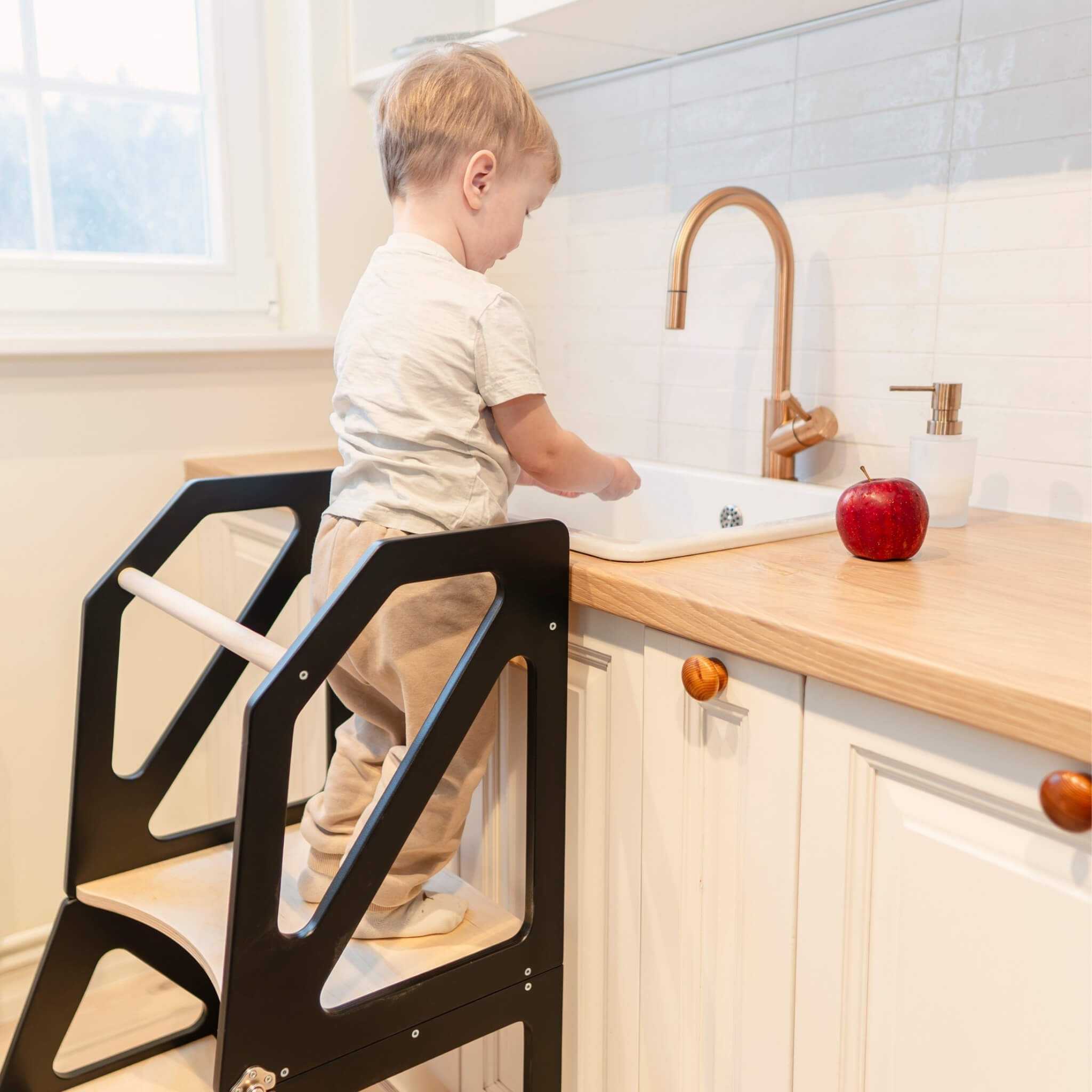 Transformable kitchen tower in use at kitchen counter, adjustable wooden 2-in-1 learning tower