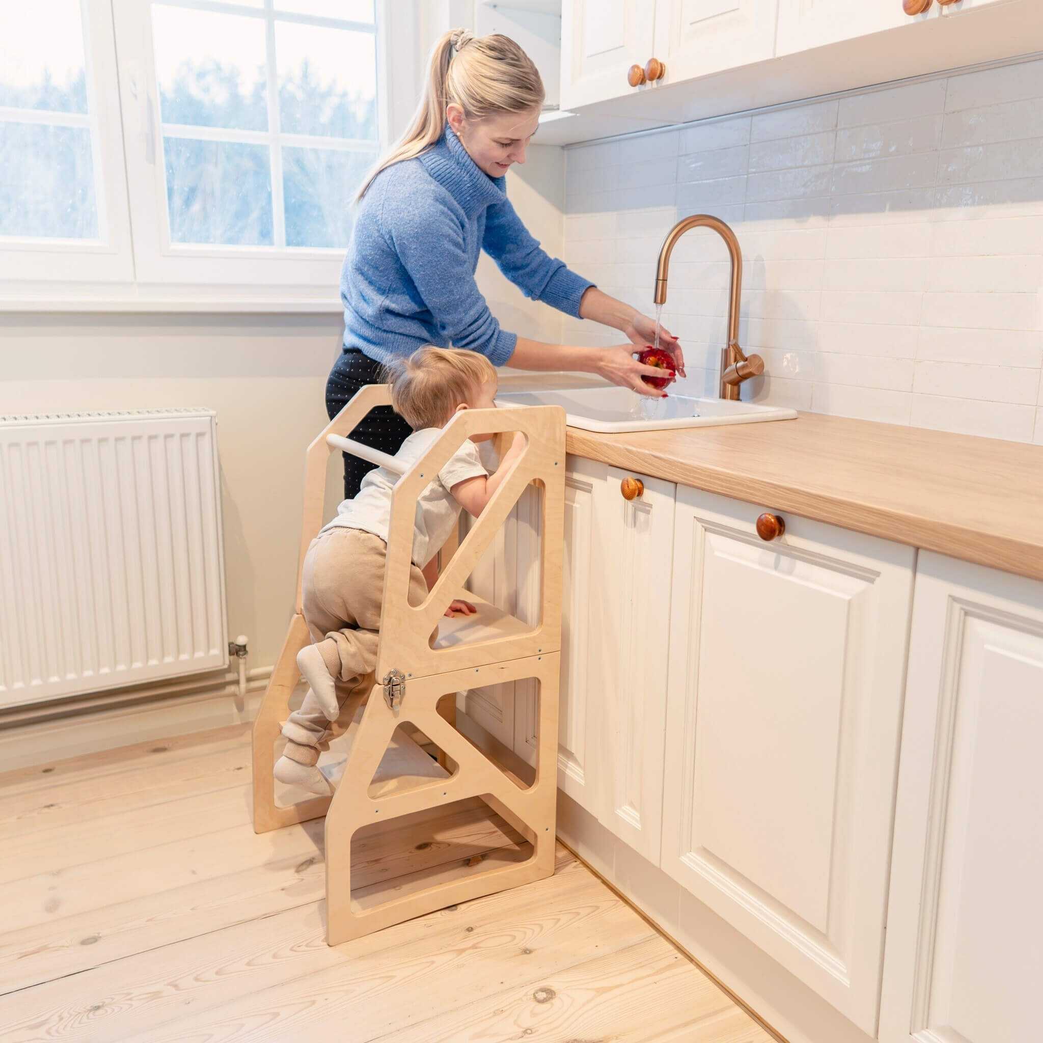 Parent assisting child in transformable kitchen tower, height adjustable wooden design