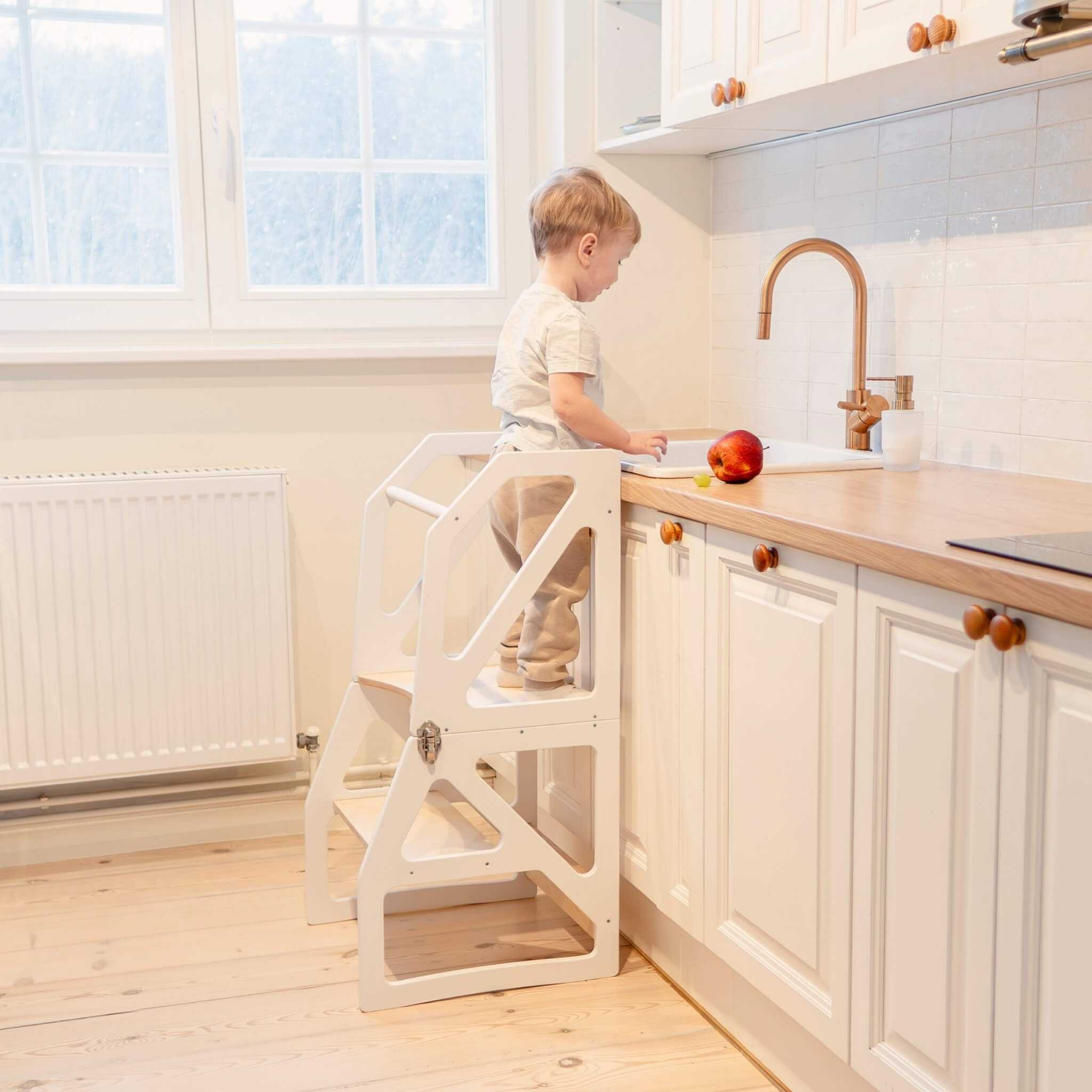 White transformable kitchen tower at kitchen counter, adjustable wooden learning tower
