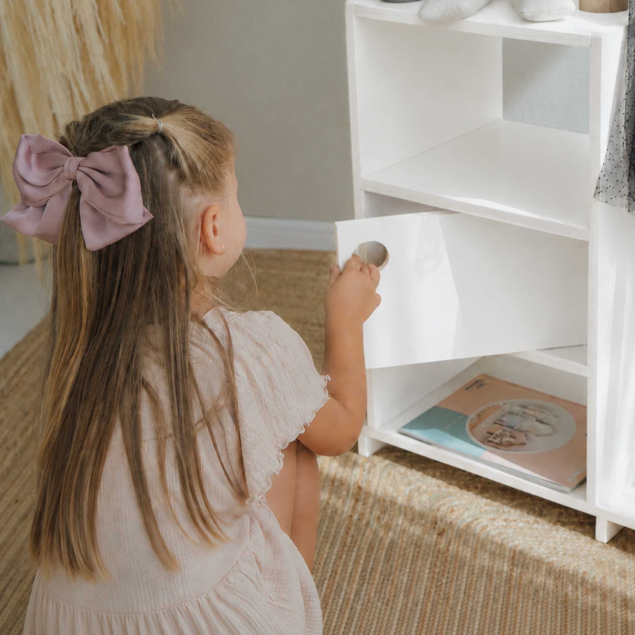 Child using a Montessori wardrobe storage shelf to encourage independence